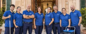 La squadra della cooperativa Serenità Igiene Salute davanti a un edificio a L'Aquila